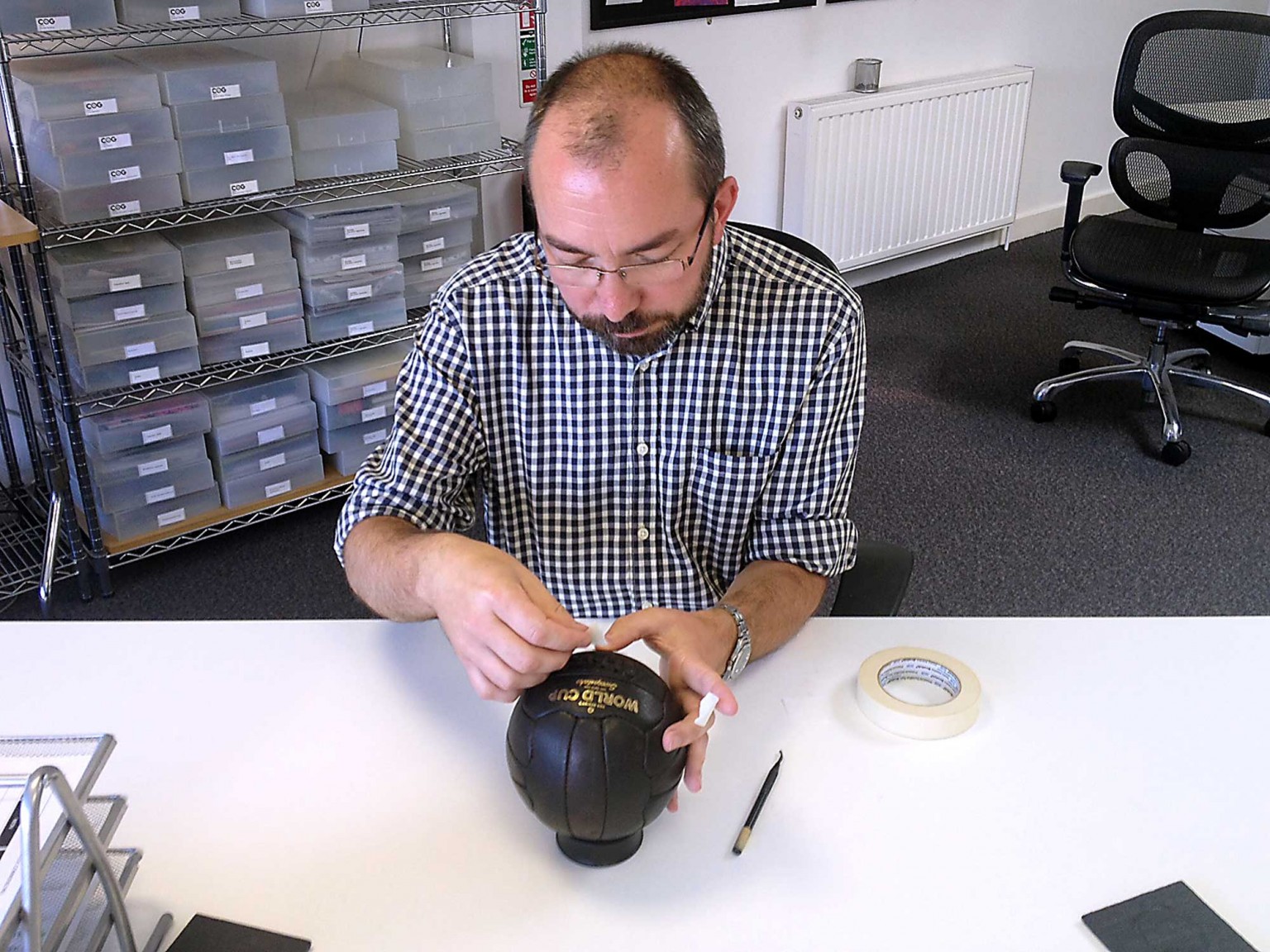 Michael, applying gold rub-down graphics to the leather ball