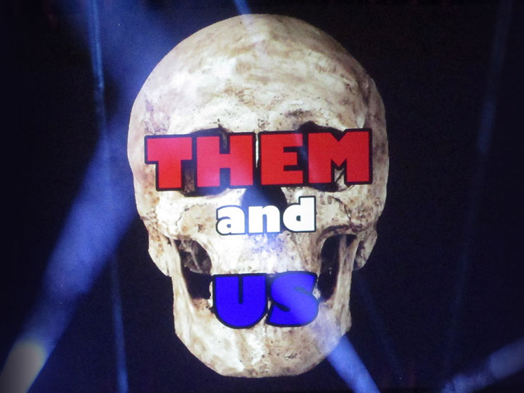 The image of a skull is overlaid with the words Them and Us.