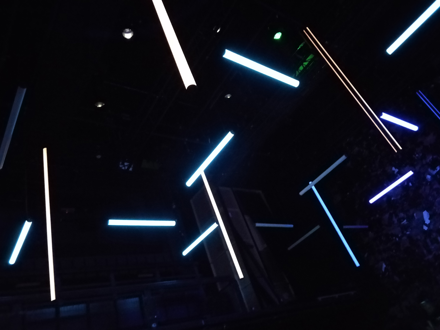 A lighting rig with illuminated tubes suspended.