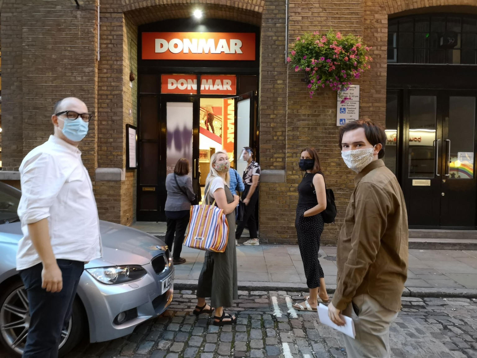 The masked Cog team, in a socially distanced queue in the street outside Donmar Warehouse.