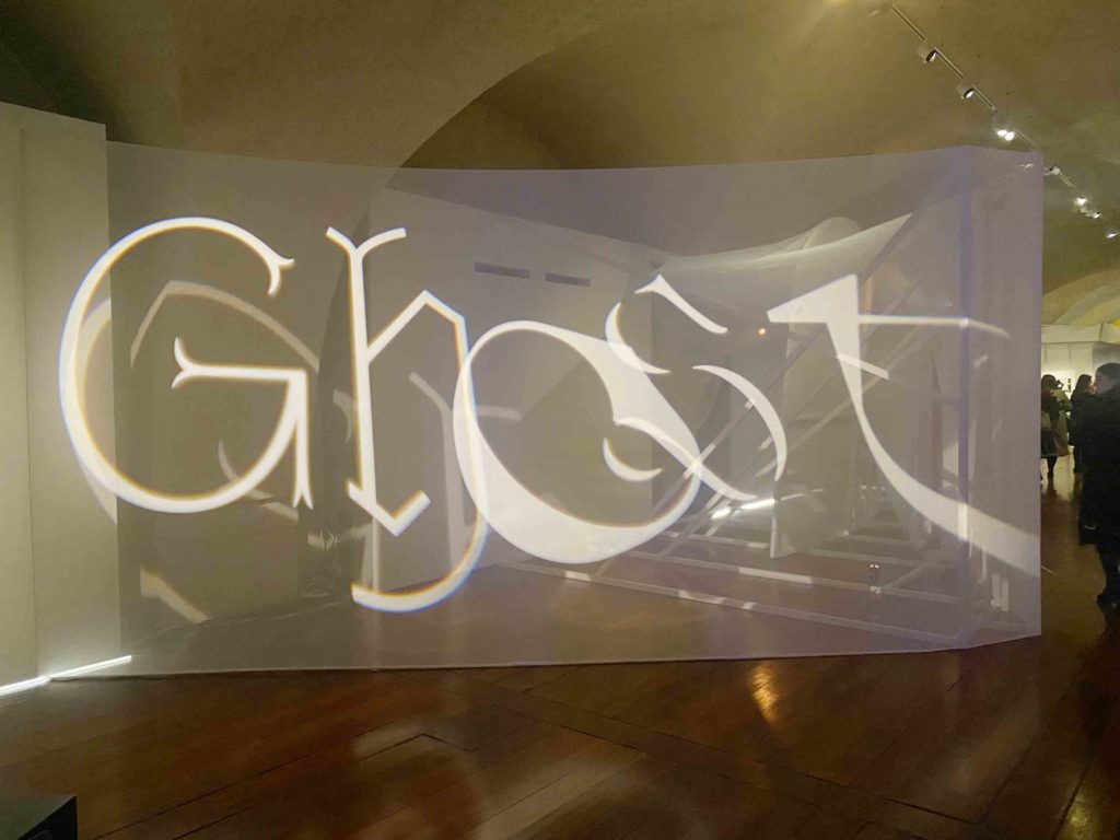 Large, projected type spells out the word Ghost, each letter is in a different font