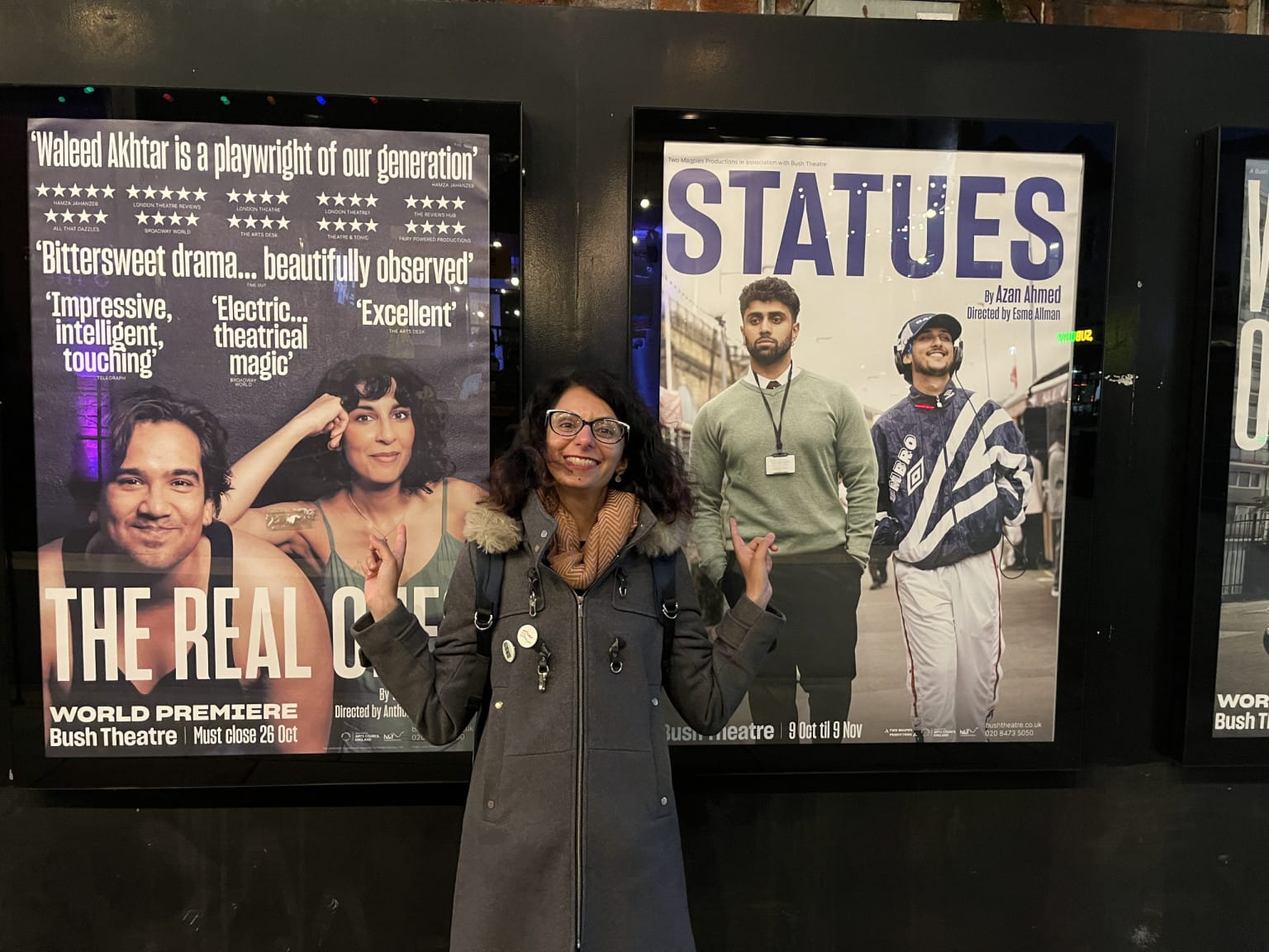 Nazma posing with The Real Ones and Statues posters